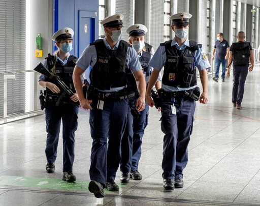 Police officers wear face masks as they walk in the airport in Frankfurt,...